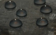 Drops of water at the surface of a novel polyolefin coating on a steel coupon, showing the low wettability of the coating